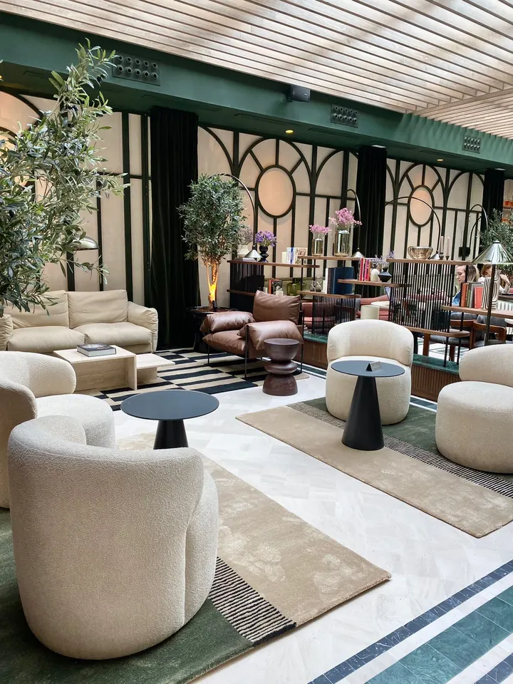 Café-restaurante del Hotel Totem con alfombras verdes, arena y de rayas bajo una galería acristalada